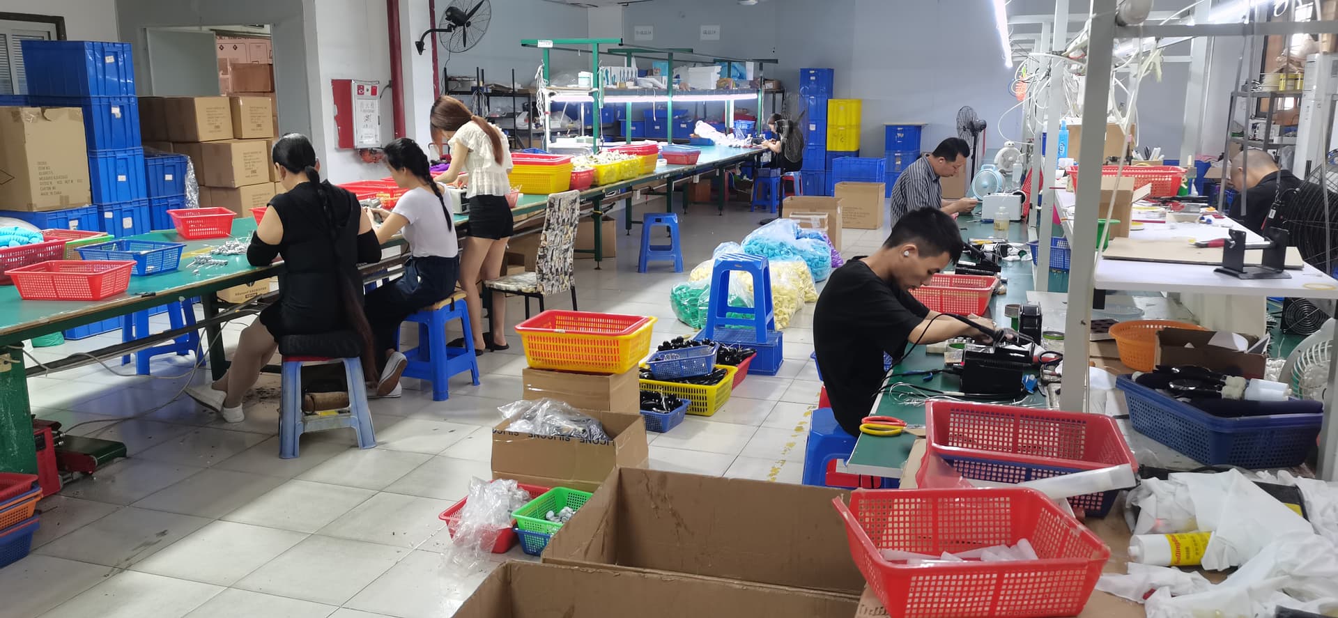 Evokomoribi Dongguan factory assembly line — workers performing manual assembly and quality inspection on adult wellness products